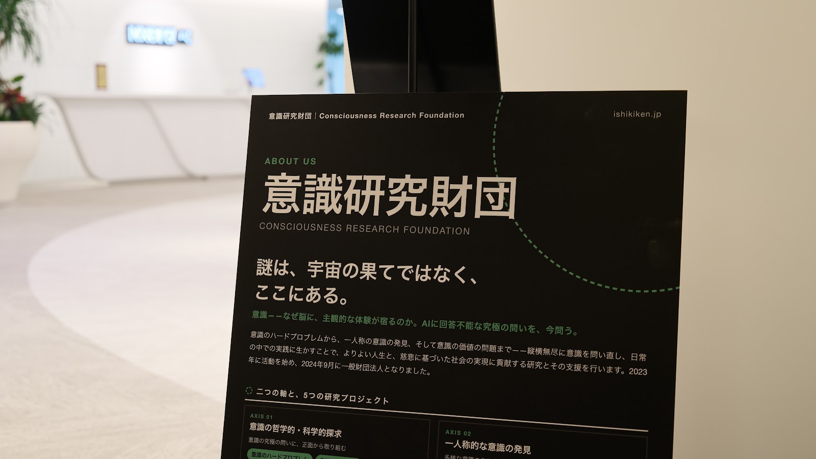 受付付近に置かれた意識研究財団の紹介パネル